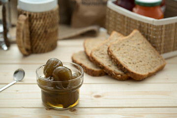 Fig jam and bread on a wooden background