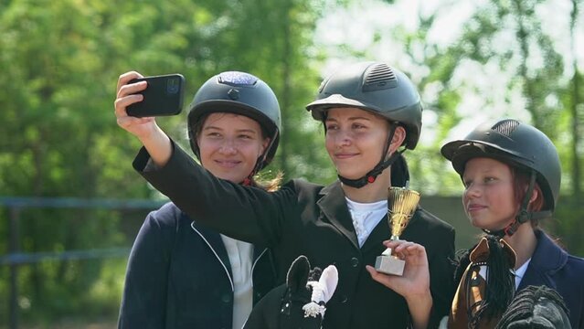 teenagers take a selfie on a smartphone. girls rejoice at the victory in the competition. Horseback riding. equestrian sports.slow motion video.Full HD video recording