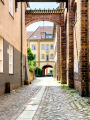 Fototapeta na wymiar Narrow European street with brick buildings and paving stones.