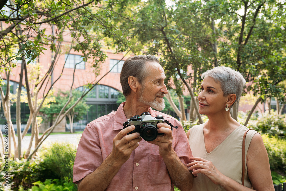 Wall mural senior couple looking at each other while standing in the park