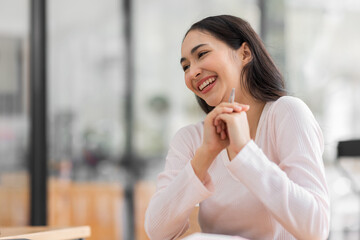 Excited happy Asian woman looking at the phone screen, celebrating an online win, overjoyed young asian female screaming with joy, isolated over a white blur background
