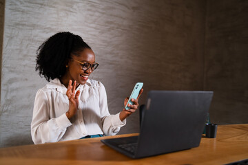 Black businesswoman working on laptop. Portrait of beautiful businesswoman in the office. Woman using the phone.