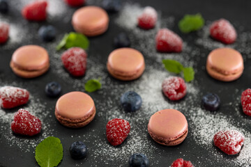 macaroons of different colors on a black background