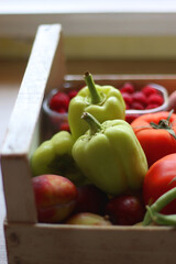 Wooden crate full of healthy seasonal fruit and vegetable. Selective focus, wooden background.
