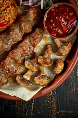 Lamb Lyulya kebab with bulgur and grilled mushrooms in a clay plate. Turkish food