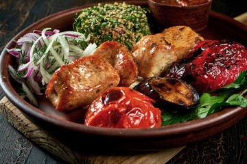 Chicken shish kebab in a plate with bulgur and grilled vegetables. Turkish food