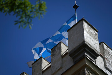 bavarian flag flies against a blue white sky