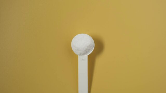 Dextrose monohydrate powder, d-Glucose or Grape sugar in measuring spoon, top view. Video 4K, Rotating. Natural sweetener, sugar substitute.