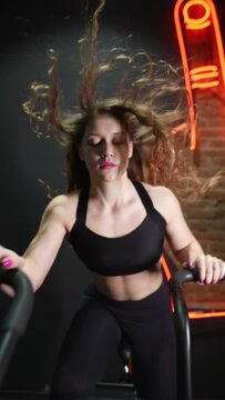 female running on elliptical orbitrek machine in fitness gym. Slow motion