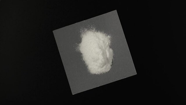 Pile of Dextrose monohydrate powder, d-Glucose or Grape sugar on dark background, top view. Natural sweetener, sugar substitute. Video 4K, Rotating.
