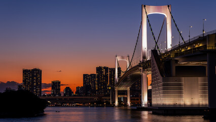 Fototapeta na wymiar Beautiful sunset colors and city lights of Tokyo and the Rainbow Bridge in Tokyo Bay