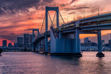 Beautiful sunset colors and clouds above the city of Tokyo and Rainbow Bridge in Tokyo Bay.