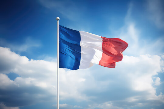 French flag flying in the wind on a flagpole against a blue sky with clouds. Blue white red France flag wallpaper.  