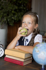 Primary schoolgirl, in school uniform, with apple.