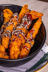 Chicken fillets croccanti conditi con salsa teriyaki e semi di sesamo serviti come antipasto in una braceria