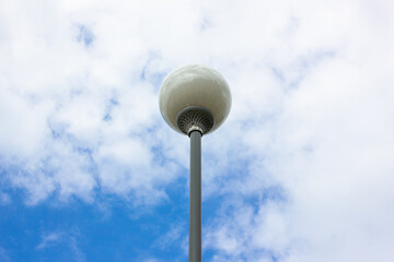 City lights during the day against the sky. Turned off lights, lamps in the city park