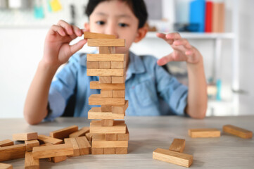 Child Boy Playing Jenga Game Exciting on Desk at Home. Careful and Attentive Keeping, Concentrate and Slowly Observing and Manage to Take It Out while Playing to Maintain Balance Objects.