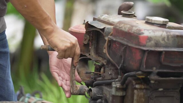 Man turning the starter to start an old biodiesel engine