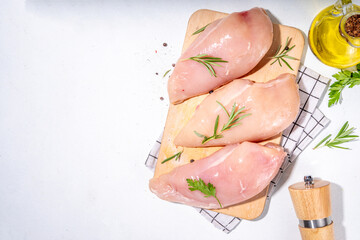 Fototapeta premium Raw chicken breast, white meat fillet steaks with greens, olive oil, spices, dinner cooking background top view copy space