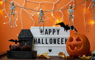 Happy Halloween white sign with black letters, pumpkin and halloween decoration.