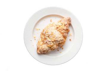 Almond croissant on a plate, top view isolated on white