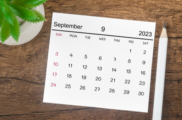 The September 2023 Monthly calendar for 2023 year with pencil on wooden background.