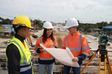 A civil team of engineers works with a blueprint at the  Construction Site of New Concrete Roads...