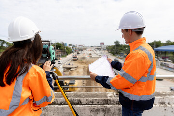 Surveyor site engineer with total positioning station on the construction site of the new road construction.