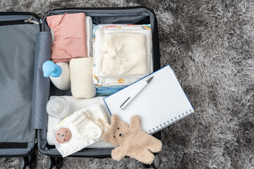 Open bag for maternity hospital. Suitcase of baby clothes prepared for newborn birth. Concept of...
