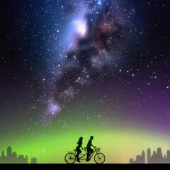 Couple on bike tandem in park. Cyclist on bicycle. Milky Way at night