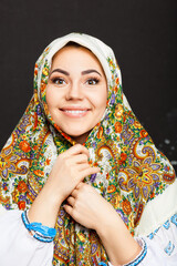 Beautiful adult Ukrainian woman in national costume. Attractive Ukrainian woman wearing in traditional Ukrainian embroidery, at black background.
