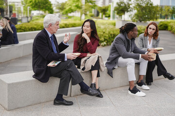 Fototapeta premium Multiracial business people eating together healthy poke food during lunch break outdoor