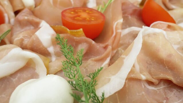 Jinhua ham, prosciutto crudo with fresh rosemary, mozzarella and tomatoes, close-up view