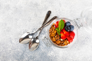 Useful breakfast. Granola bowl with yogurt and fresh berries on a textured kitchen table.Acai and spirulina bowl.Bowl of Greek yogurt with granola, almonds, blueberries, raspberries and strawberries.