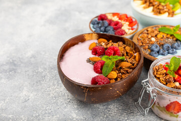 Useful breakfast. Granola bowl with yogurt and fresh berries on a textured kitchen table.Acai and spirulina bowl.Bowl of Greek yogurt with granola, almonds, blueberries, raspberries and strawberries.