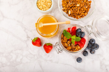 Granola bowl with yogurt and fresh almonds, blueberries, raspberries,peach and strawberries on a marble kitchen table.Acai and spirulina bowl.Healthy breakfast concept.copy space.Place for text.