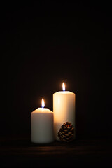 Fototapeta na wymiar Burning candles and christmas decorations on a dark background