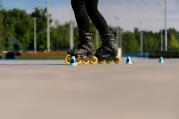 sporty girl practicing tricks on roller skates in park on city background enjoying roller skating...