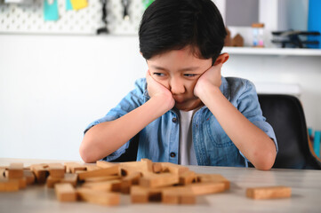 Child Boy Playing Jenga Game Exciting on Desk at Home. Feeling Fun and Learning to Fail when Making a Mistake.