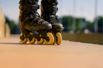 sporty girl practicing tricks on roller skates in park on city background enjoying roller skating...