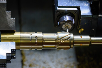 The CNC lathe machine slot milling the brass shaft parts by milling spindle.