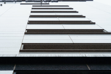 Wide, low-height windows are placed side by side on the marble-clad apartment walls.