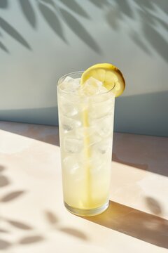 Glass of cold lemonade with lemon slice on marble surface, created using generative ai technology
