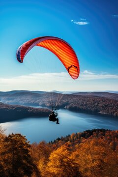 Paraglider drifting over countryside landscape with blue sky, created using generative ai technology
