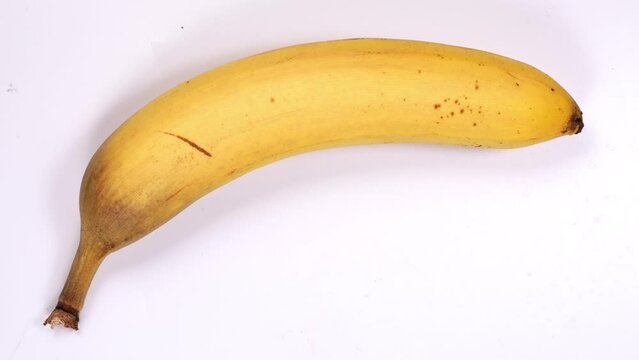 Banana rotting on clean white background, timelapse shot of fruit rots