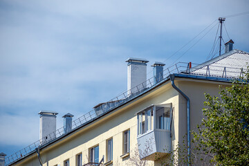 Chimneys on the roof of a residential building on a summer day
