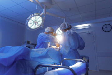 A male surgeon and his female assistant are operating on a patient and being very steady with the...