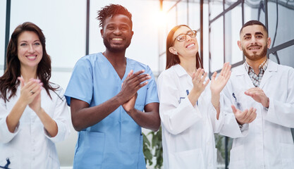 Successful team of different doctors clapping hands