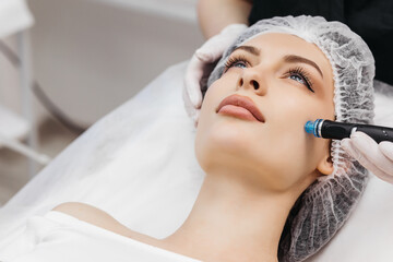 Pleasant relaxation. Beautiful young woman closing her eyes while having a hydrafacial procedure