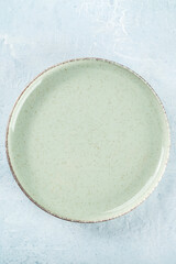 An empty green plate, top shot on a slate background, simple tableware